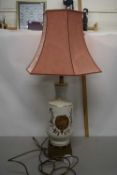 A cream and gilt glazed table lamp with peach damask shade