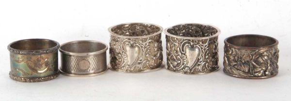 A pair of late Victorian silver serviette rings elaborately embossed with cherubs, scrolls etc,