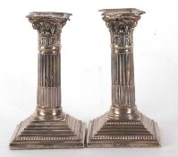 A pair of late Victorian silver candlesticks having Corinthian columns with detachable nozzles on