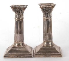 A pair of late Victorian silver candlesticks having Corinthian columns with detachable nozzles on