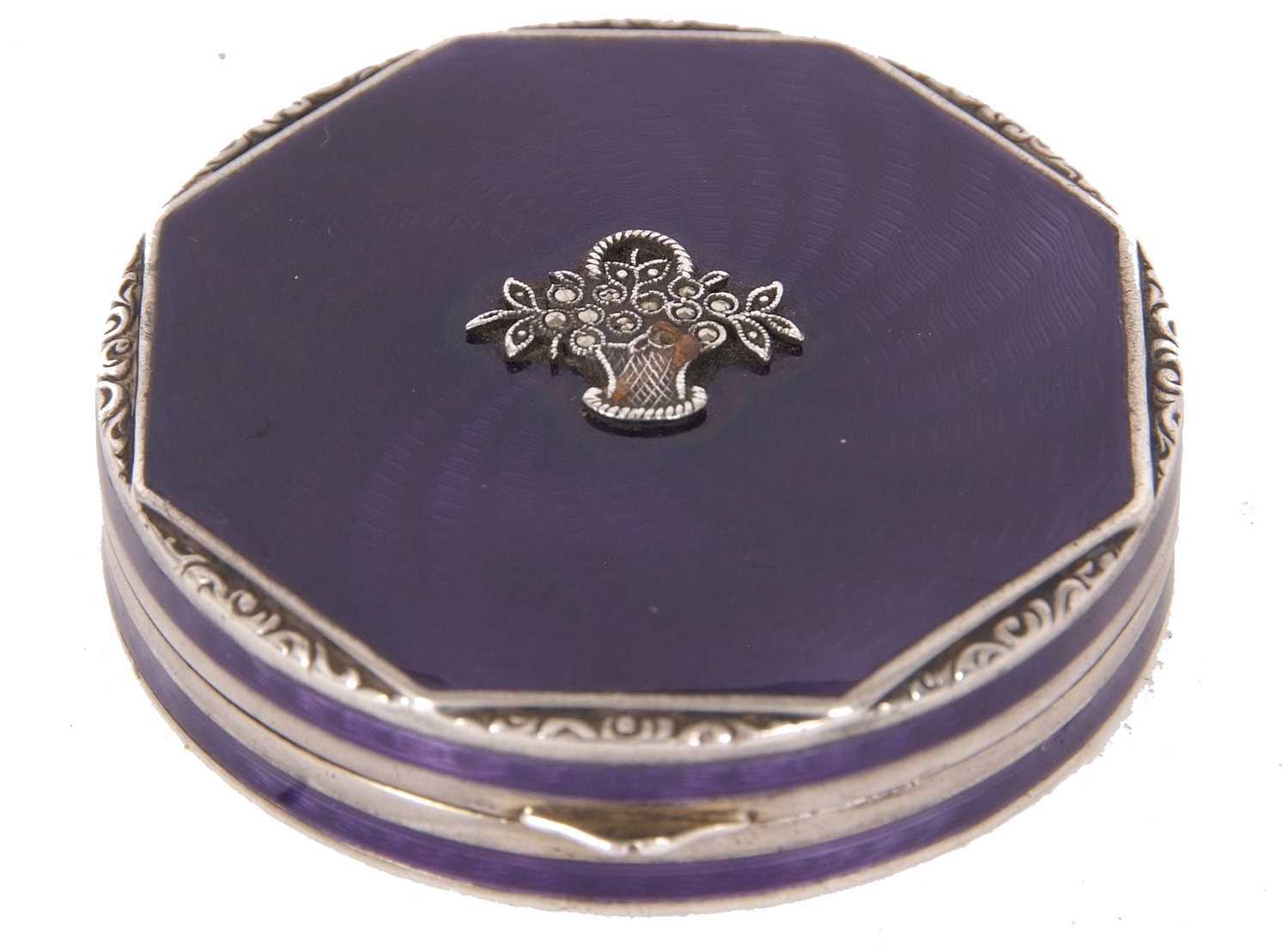 A white metal and enamel compact of octagonal form, the lid decorated with a purple guilloche enamel