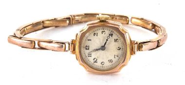 A 9ct gold cased ladies wristwatch on an expanding yellow metal bracelet which is stamped 9ct on