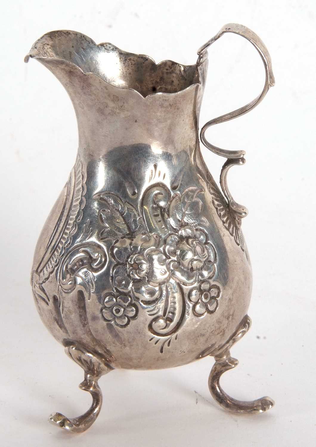A late Victorian silver cream jug having a round bellied body with chased and embossed floral - Image 3 of 4