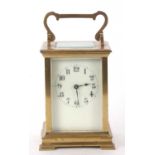 A four glass carriage clock with enamel dial and black Arabic numeral hour markers, it has a key