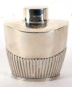 An Edwardian silver caddy of tapering oval form, part fluted body with pull off lid, hallmarked