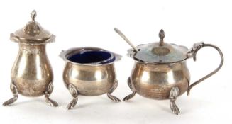 A George V three piece silver condiment set comprising pepper, hinged lidded mustard and liner, open