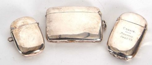 A group of three silver vesters, two of plain form one with a personlised engraving, mixed dates and