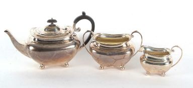 A George V silver three piece tea service comprising teapot, a twin handled sugar bowl and a milk