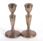 A pair of Elizabeth II silver candle sticks of plain design with reeded edges, loaded bases and 15cm
