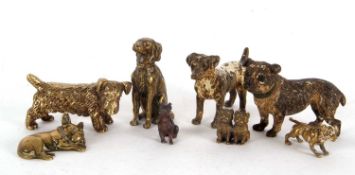 A tin containing eight various dog ornaments, two gold painted bronze examples, and five brass and