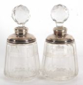 A pair of glass scent bottles and stoppes with fasceted decoration to bodies and with hallmarked