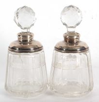 A pair of glass scent bottles and stoppes with fasceted decoration to bodies and with hallmarked