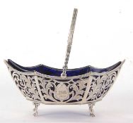 An Edwardian silver pierced swing handle sugar basket of boat shape with wavy reeded edge and