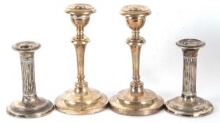A pair of Edwardian candlesticks with removeable nozels on tapering knopped stems on loaded bases,