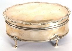 An early 20th Century silver ring box of shaped oval form, the plain hinged lid with applied