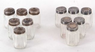 A group of six pairs of miniature salt and peppers, each with fasceted glass bodies, the lids
