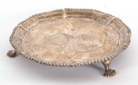 A George III silver card salver of circular form supported on three cast feet, the centre chased