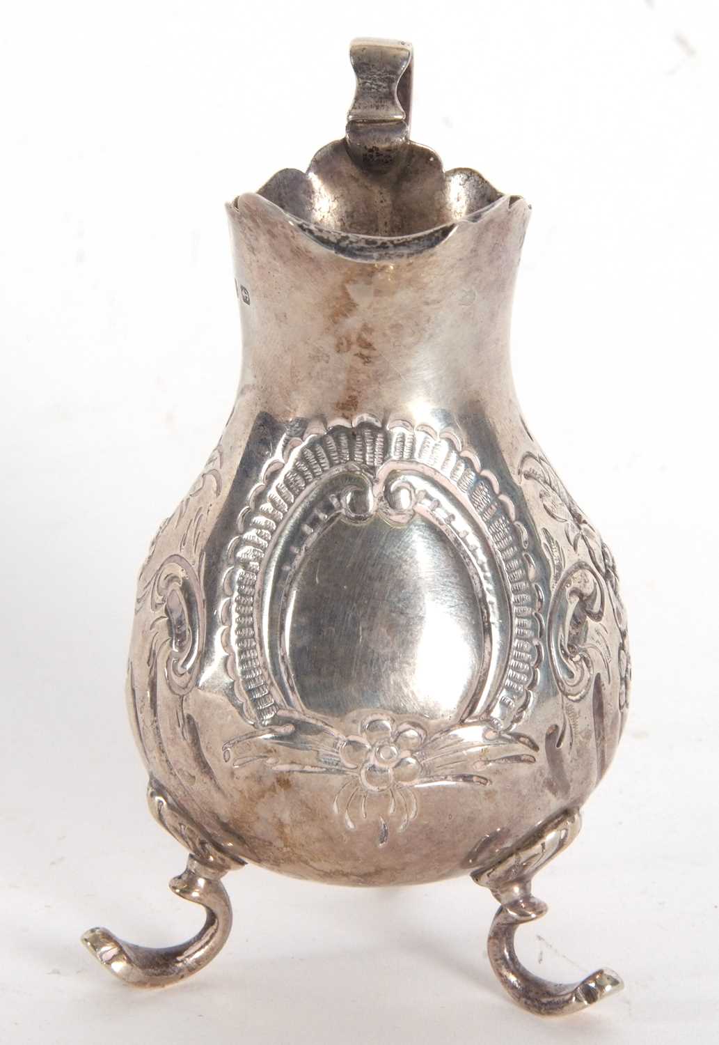 A late Victorian silver cream jug having a round bellied body with chased and embossed floral - Image 2 of 4