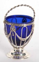 An Edwardian silver sugar basket having strap work body detail, decorated with tied ribbons and