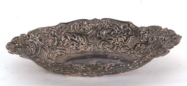 A Victorian silver dish of oval shape, elaborately embossed with C scrolls and flowers etc,