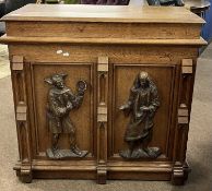 An unusual Victorian oak cabinet, the front decorated with two carved figures, the sides with