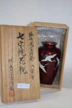 A Japanese porcelain Cloisonne vase finely enamelled with three cranes in flight on a mottled red