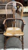 A 19th Century yew and elm seated Windsor type chair with turned legs and crinoline stretcher