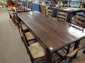 A large oak refectory dining table with H formed stretcher together with a set of ten rush seat