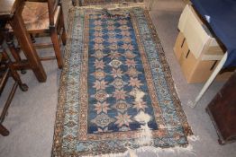 A 19th Century Middle Eastern wool floor rug with a large central blue panel, 186 x 100cm, very worn