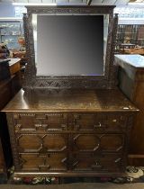An early 20th Century heavily carved Jacobian style oak dressing chest with adjustable mirror