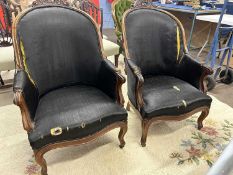 A pair of mid 19th Century armchairs with carved show wood frames and black upholstery