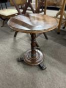 A small Victorian mahogany wine table with circular top over a turned column and a platform base,