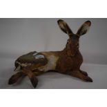 A ceramic sculpture of a rabbit in naturalistic colours