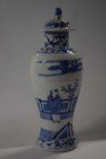 A Chinese porcelain vase of baluster form with cover, decorated in Kangxi style with figures by a