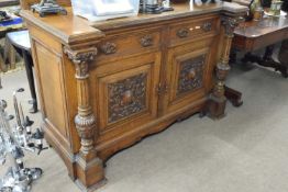 Late Victorian oak sideboard with two drawers and two panelled doors with carved decoration, 150cm