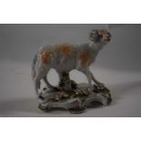 An English porcelain model of a ram on shaped base applied with flowers, possibly Bow or Derby, 10cm