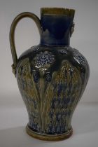A large 19th Century Doulton Lambeth jug with an applied mask design to the spout and incised leaf