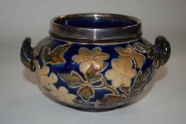 A small Doulton Lambeth bowl with white metal rim, the bowl with an incised floral design and