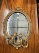 A small Girandole type wall mirror of oval form, with moulded plaster frame and twin sconces, 56cm