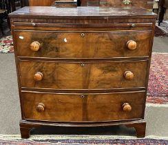 A Victorian mahogany bow front chest of drawers with three full length drawers and a pull out