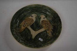A Studio Pottery dish with two birds in branches on a green ground, 30cm diameter