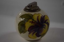 A Moorcroft Pottery table lighter, the white ground with hibiscus decoration with paper label to
