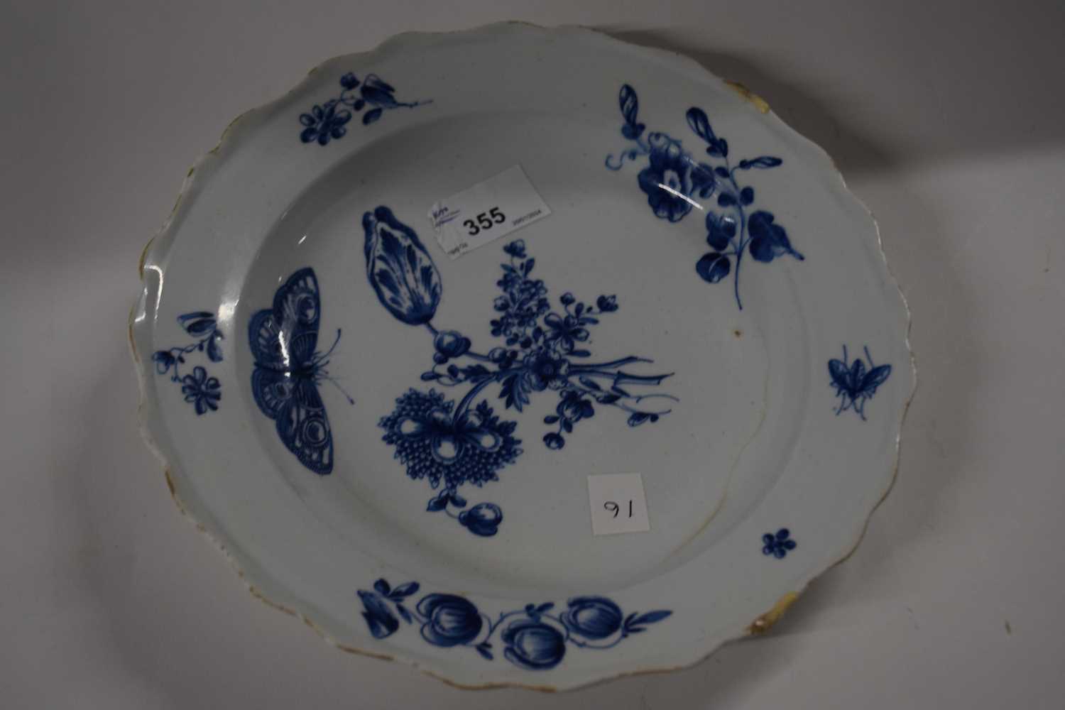 An 18th Century English porcelain plate painted with floral sprays and butterfliees in blue and