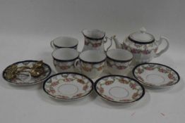 A miniature tea set with floral decoration comprising teapot, milk jug, four cups and saucers