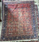 A very worn Persian wool rug decorated with large central red panel, 143 x 130cm (Item 48 on