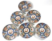 A group of five small Japanese porcelain dishes with Imari design and including panels of ships,