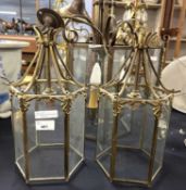 A pair of small brass mounted hexagonal ceiling lantern light fittings with panelled glass sides,