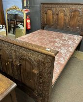 An early 20th Century carved oak double bed frame in the Jacobian style to accommodate a mattress