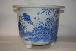 A large early 20th Century Japanese porcelain jardiniere raised on three stub feet with blue and