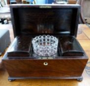 A rosewood sarcophagus formed tea caddy with hinged lid opening to an interior with central glass